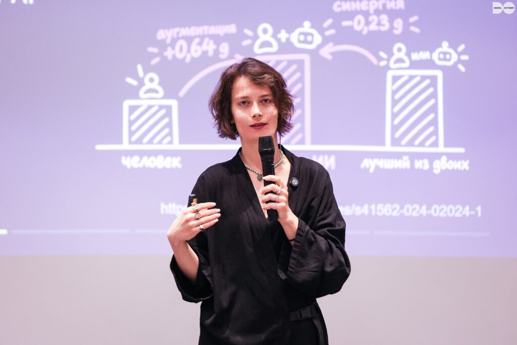 Мария Осетрова с микрофоном у экрана презентации — Ереван, 29 сентября 2026